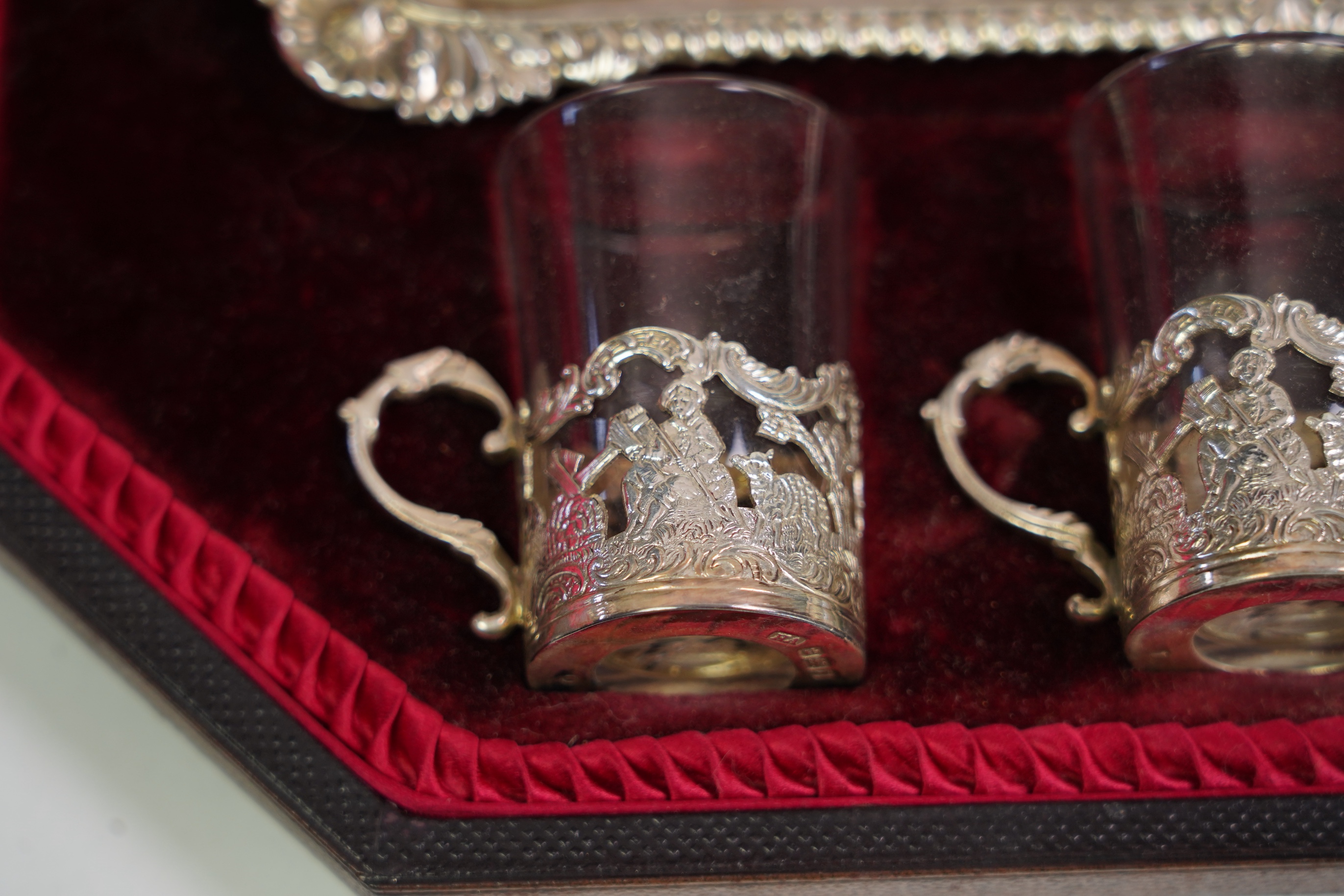 An Edwardian cased silver small two handled serving tray with six matching silver mounted glass liqueur tots, by Atkin Brothers